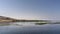 A small green island is visible on the calm blue water of the Nile