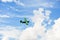 Small green plane flying in blue sky