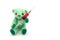 Small green teddy bear holding injection syringe on white background