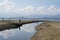 Small group of anglers fishing in arid or dried up river channel supplying water to dam Liptovska Mara.