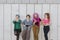 small group of teen women with technology isolated against a grey wall