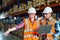 A small group of warehouse workers have a briefing in a large distribution center