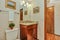 Small guest Bathroom with wood vanity and open door to hallway
