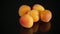 Small handful of ripe apricots on black background