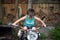 Small happy boy sitting and trying to ride old vintage damaged rusty motobike