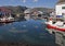 Small harbor at a norwegian coastal village with Hurtigrouten harbor stop and reflection in harbor of fishermens boats