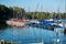 Small harbor with sailing boats and pedal boats at the footbridge