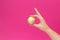 A small head of cabbage in the hand of a girl on a pink background, the concept of vegetarianism and diet, copy space