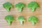 Small heads of broccoli on wooden background. top view