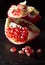 Small heap of pomegranate seeds on black slate surface