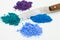 Small heaps of color powder with a spatula.