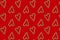 Small hearts made of Christmas candies on red. Seamless pattern. Wrapping paper concept, wallpaper, fabric pattern.