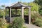 A small hexagonal gazebo in small public park by the river Coly in Colyton, Devon