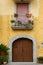 Small historic courtyards on old streets in southern Italy. Flowers in pots and antique wooden doors in stone medieval houses