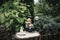 Small home garden private fountain with meditating Buddha statue between trees and bushes.