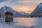 Small house in frozen lake Predil with sunset in winter