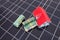 Small house model and Australian dollar banknotes on solar panels background