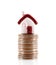 Small house model lifted by a stack of dollar coins on white background