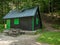 Small house with a wooden table and bench in the woods. Mountain shelter in the Bucegi mountains