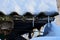 Small icicles on a slate roof under the snow