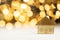 small icon house with gold shiny bokeh background, investment mortgage real estate concept