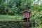 Small idyllic pond with boat hut and bathing jetty