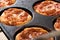 Small individual pizzas in a baking tray