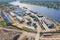 Small industrial port for timber logs and containers, loading and unloading on sea and rail transport. Aerial view