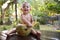 A small infant baby takes out a straw from a green coconut which is made in the shape of a halloween symbol