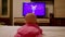 Small infant watching cartoons on TV screen