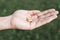 Small intra channel hearing aid device in a man`s hand.