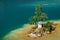 Small island in clean turquoise Wolfgangsee lake in Salzkammergut in Austria