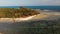 Small island and coral reef in ocean. Drone view of green uninhabited island and amazing coral reef in calm sea on sunny