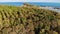 Small island and coral reef in ocean. Drone view of green uninhabited island and amazing coral reef in calm sea on sunny