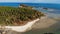 Small island and coral reef in ocean. Drone view of green uninhabited island and amazing coral reef in calm sea on sunny day in