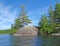 Small island with green trees in blue water of Charleston lake