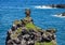 Small jagged island of lava in the Pacific Ocean at the black sand beach on the Island of Maui in the State of Hawaii.