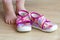 Small kids foot with pink girls slippers in front