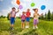 Small kids with four balloons in green meadow