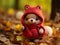 a small knitted bear wearing a red hoodie