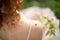 A small ladybug is sitting on the shoulder of a young woman