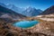 Small lake with blue water and snow covered mountains