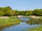 Small lake with bridge and meadows and trees