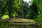 Small lake in a forest with trees and a bridge in Zamecky Park, in Hluboka nad Vltavou Czech Republic