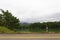 A small lake near the mountains in the rainy morning. Asphalt road along the lake. Perfect for holiday travel