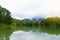 A small lake near the mountains in the rainy morning. Asphalt road along the lake. Perfect for holiday travel