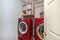 Small laundry room interior with red laundry machines