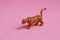 Small leopard plastic toy on a pink background