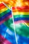 Small LGBT flags against the background of a large banner of sexual minorities filling the picture, vertical photo