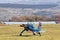 A small light-engine aircraft stands on a field airfield